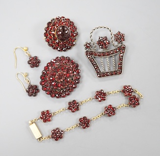 A Victorian gilt metal and facetted garnet set cluster brooch, 27mm, two other similar brooches, a bracelet and pair of earrings.